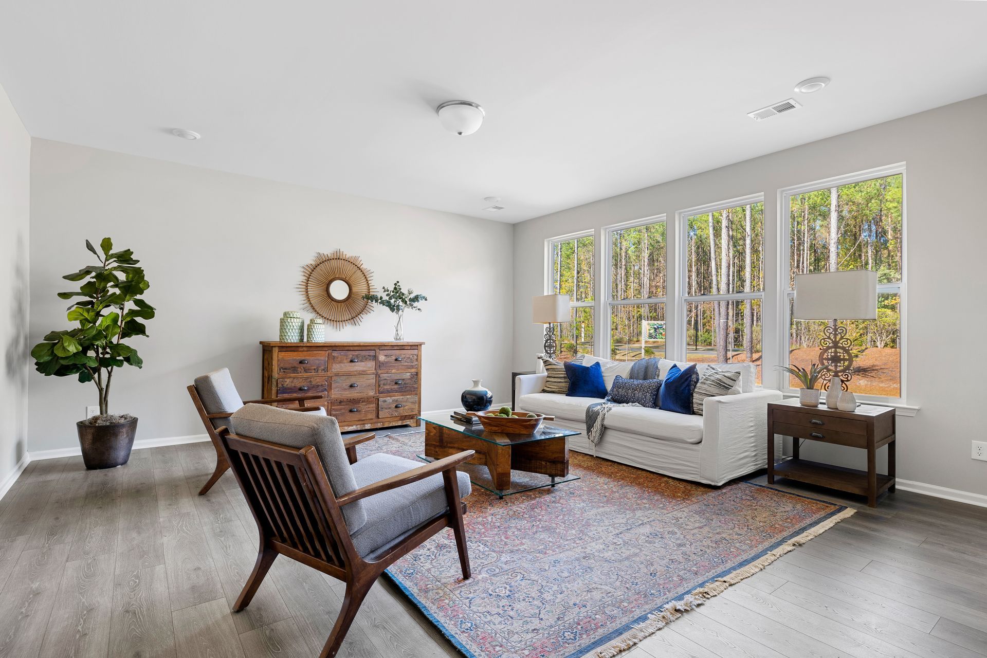 A living room with a couch , chairs , and a rug.