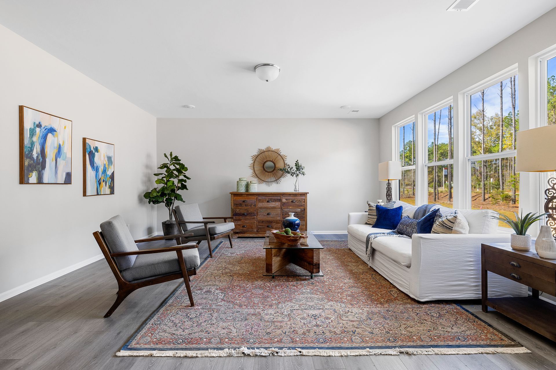 A living room with a couch , chairs , and a rug.