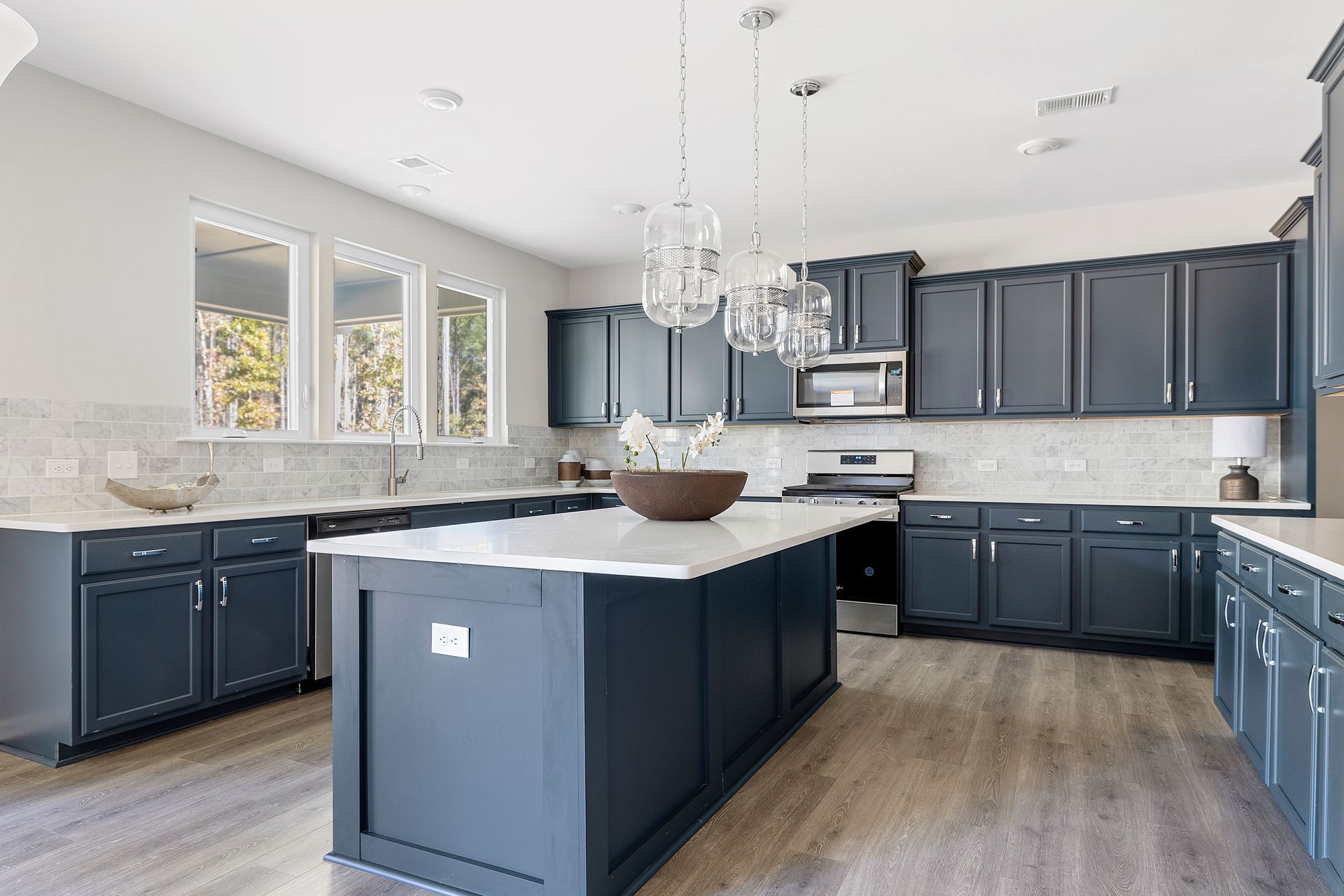 A kitchen with blue cabinets and a large island in the middle.