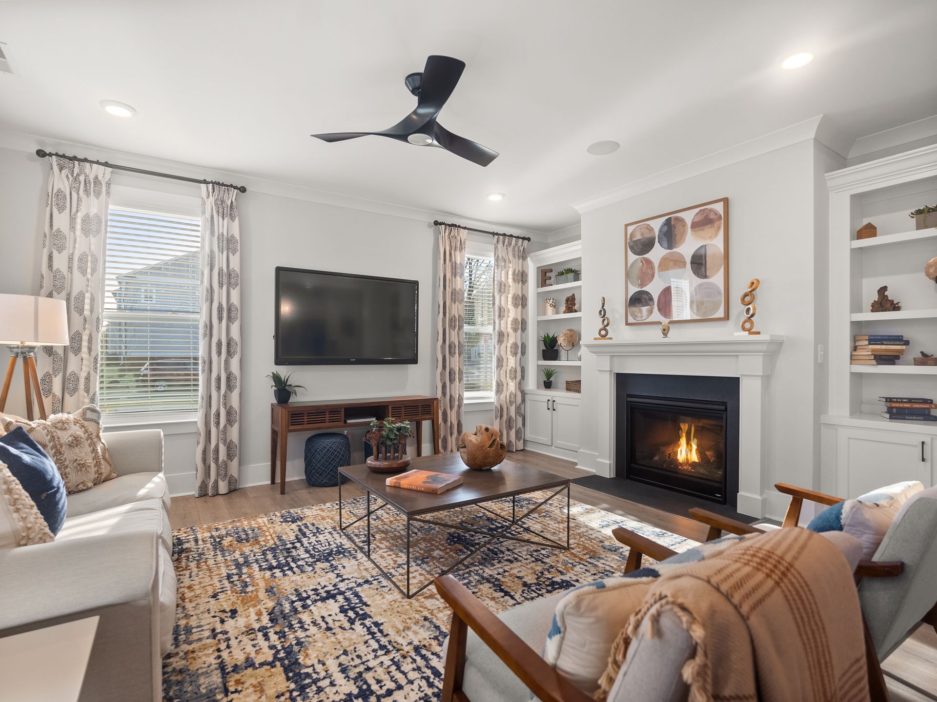 A living room with a fireplace and a flat screen tv.