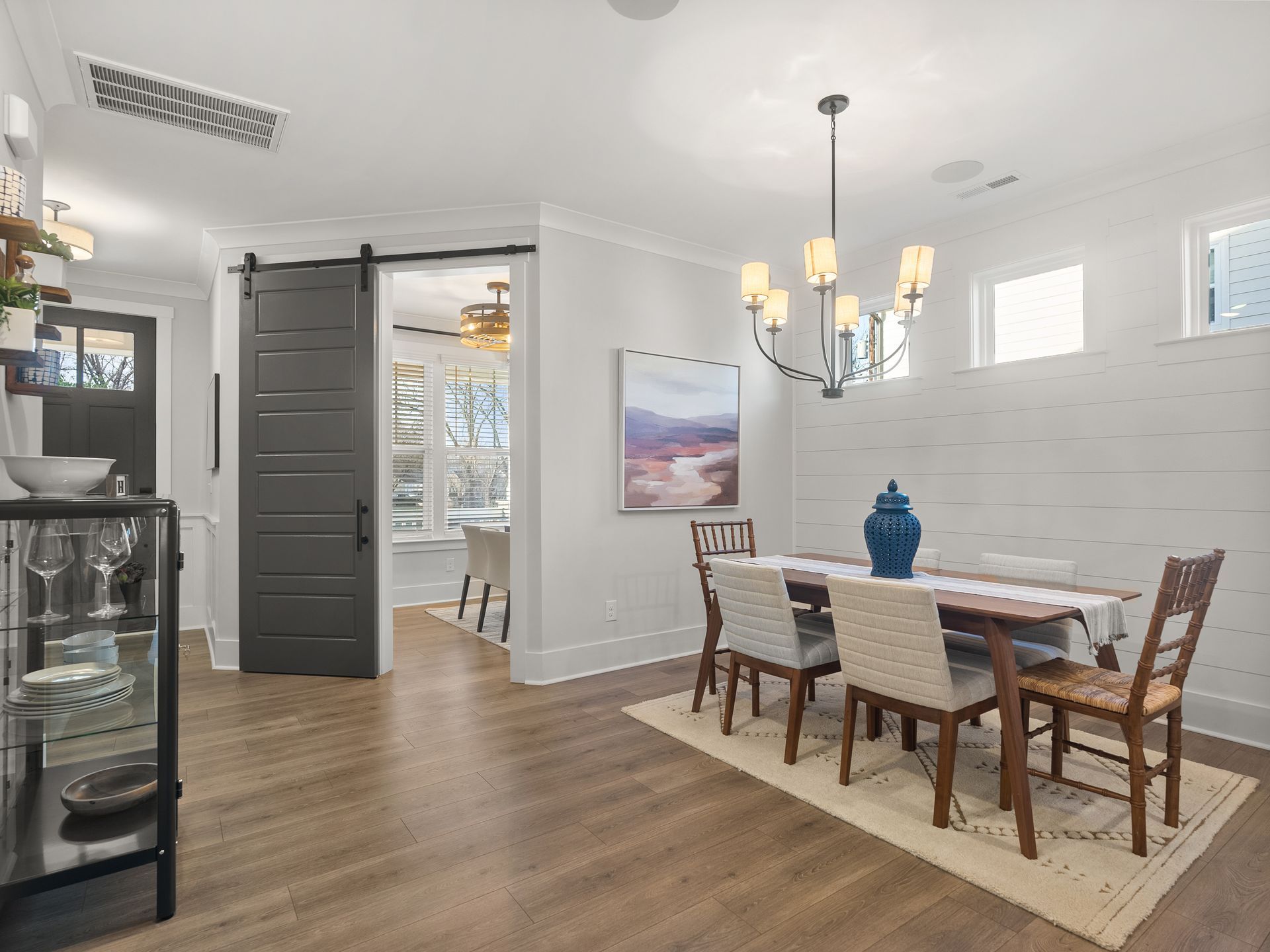 a dining room with a table and chairs and a sliding barn door .