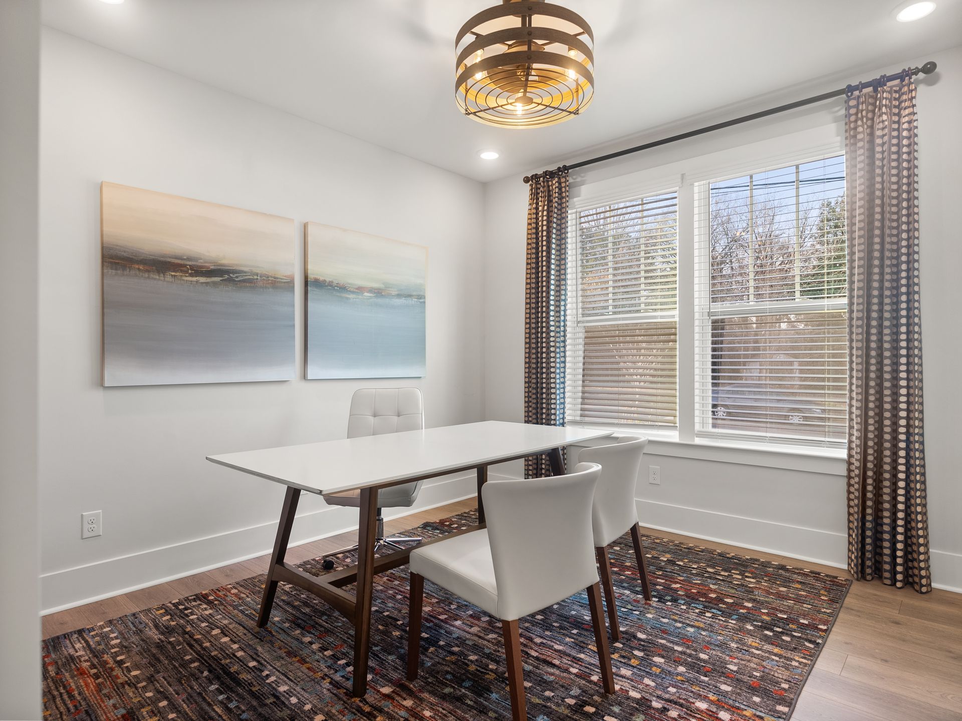 A dining room with a table and chairs and a rug.