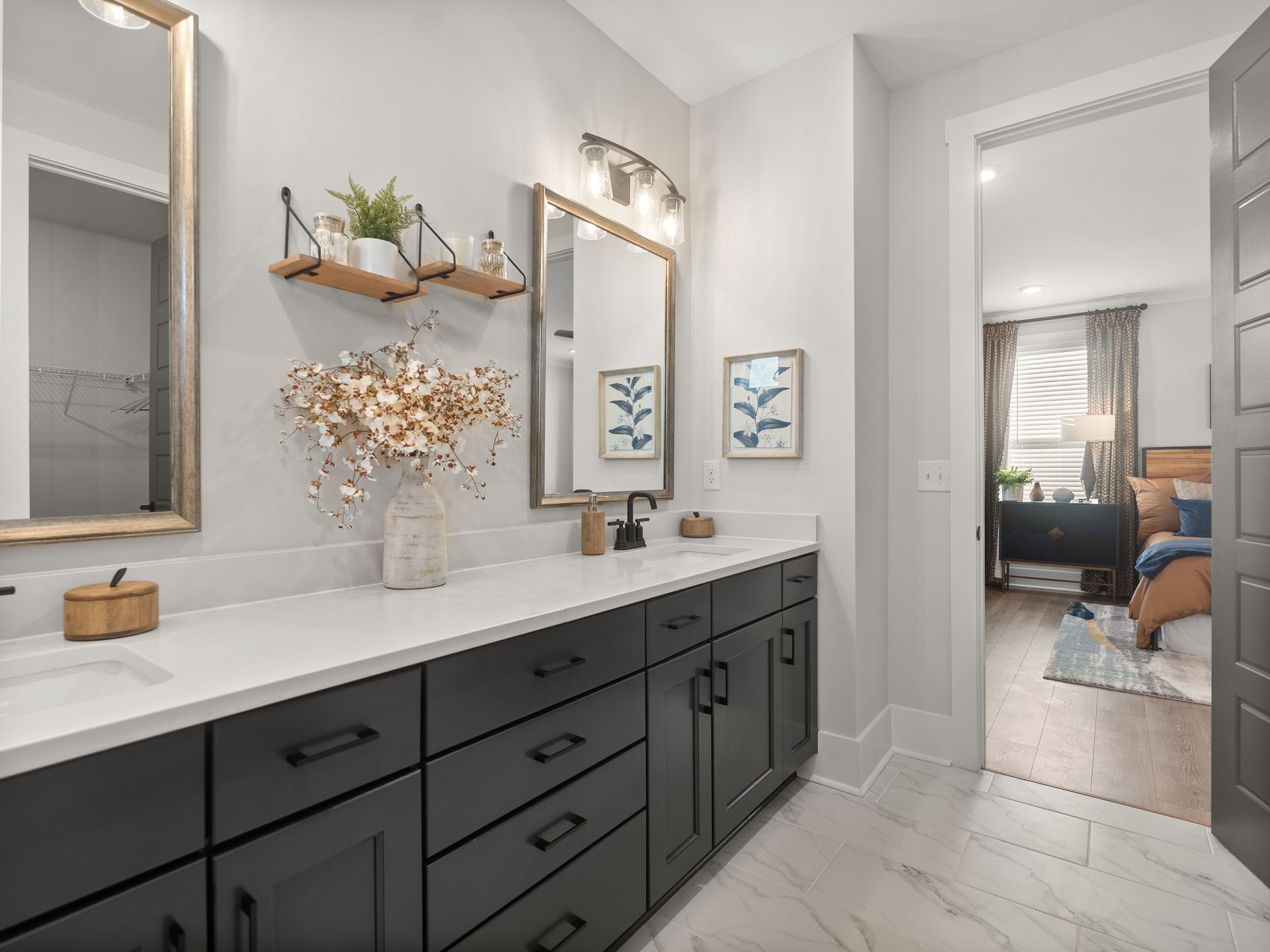 A bathroom with black cabinets , a sink , a mirror and a walk in shower.