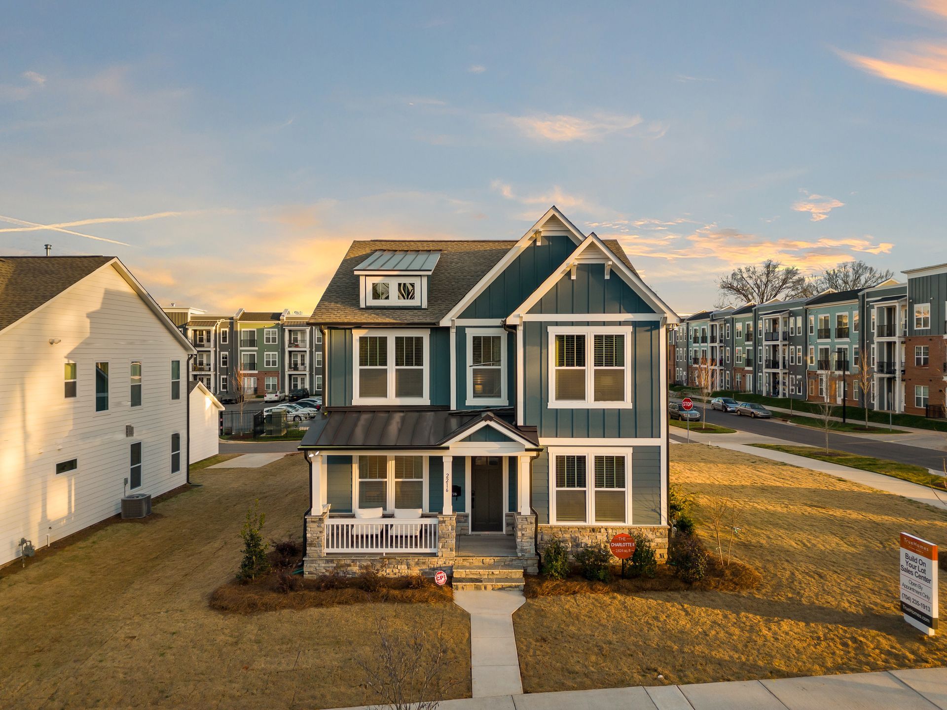 An aerial view of a blue and white house in a residential area.