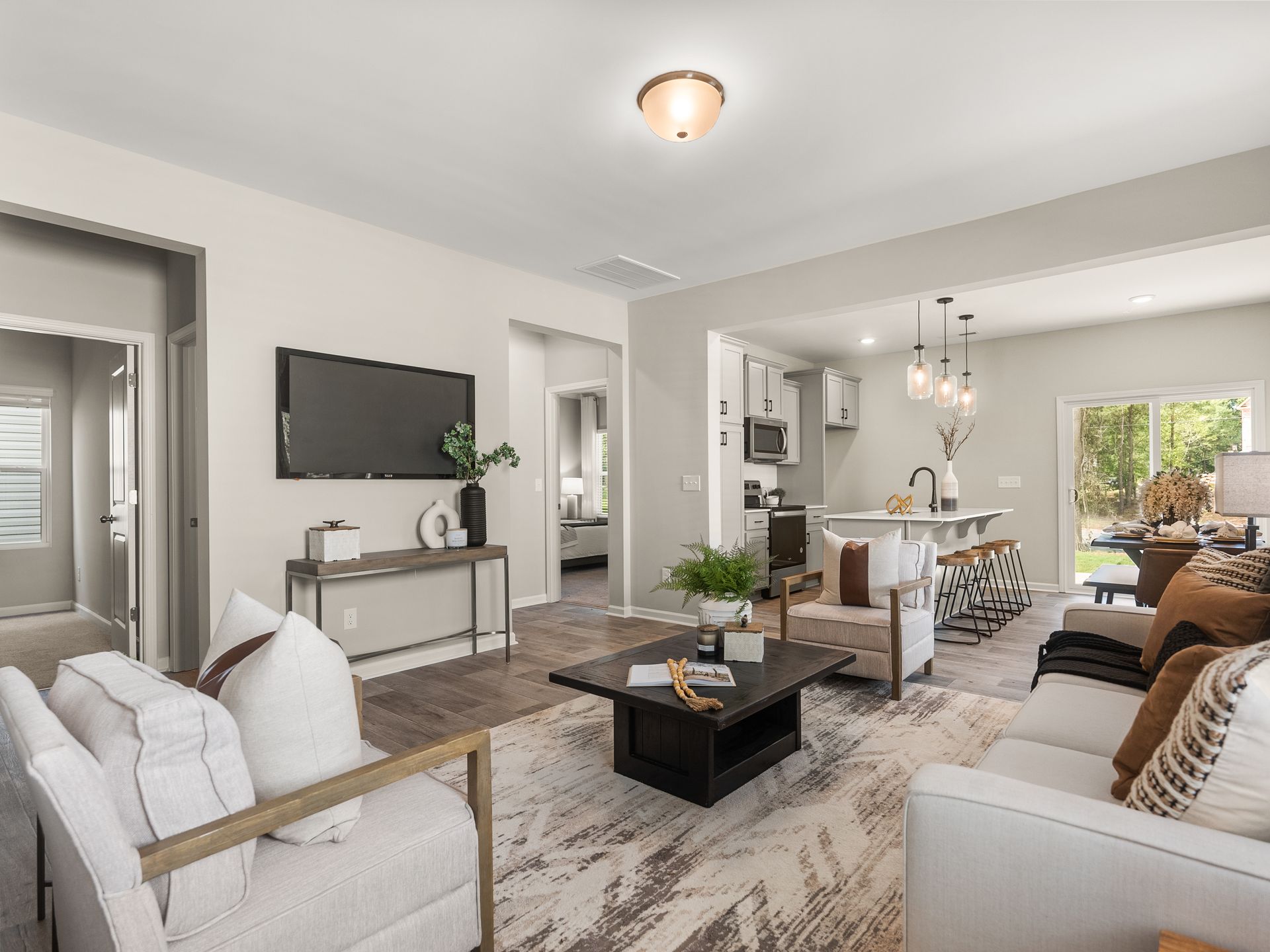 A living room with a couch , chairs , coffee table and television.