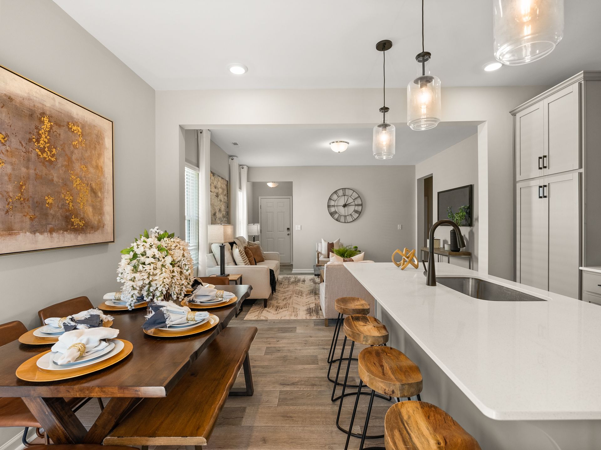 A kitchen with a table and chairs and a clock on the wall.