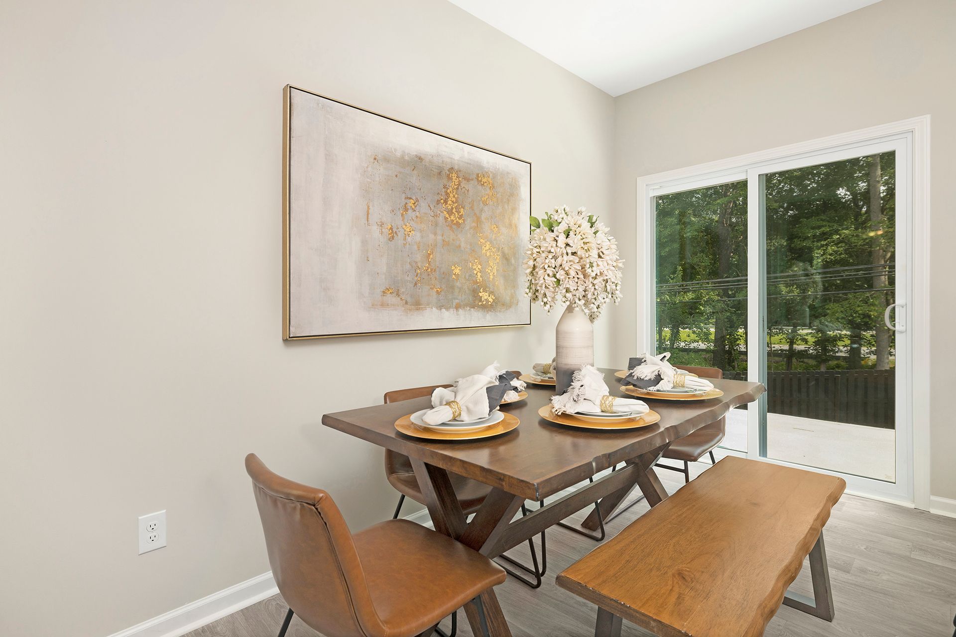 A dining room with a table and chairs and a bench.