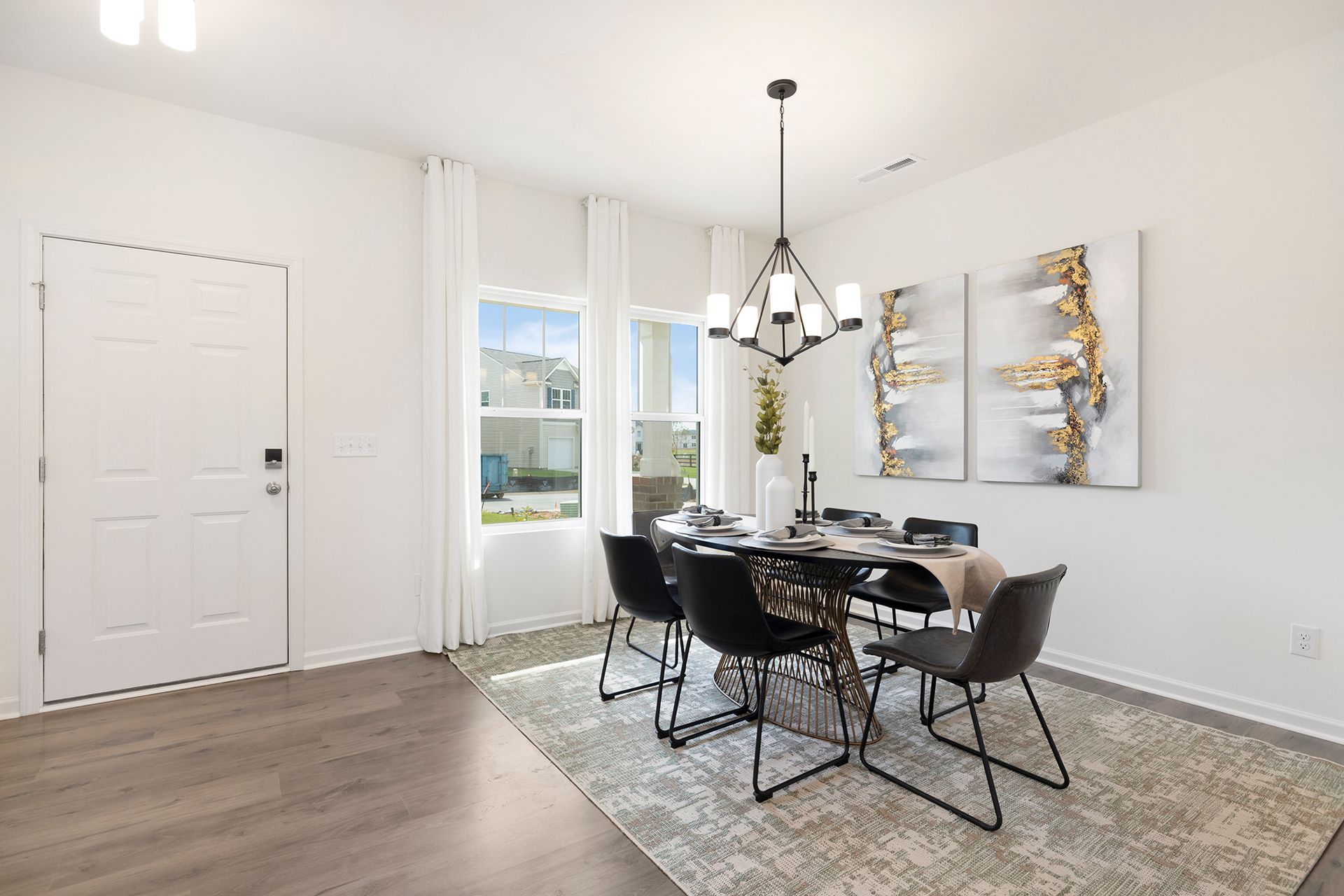 A dining room with a table and chairs and a chandelier.