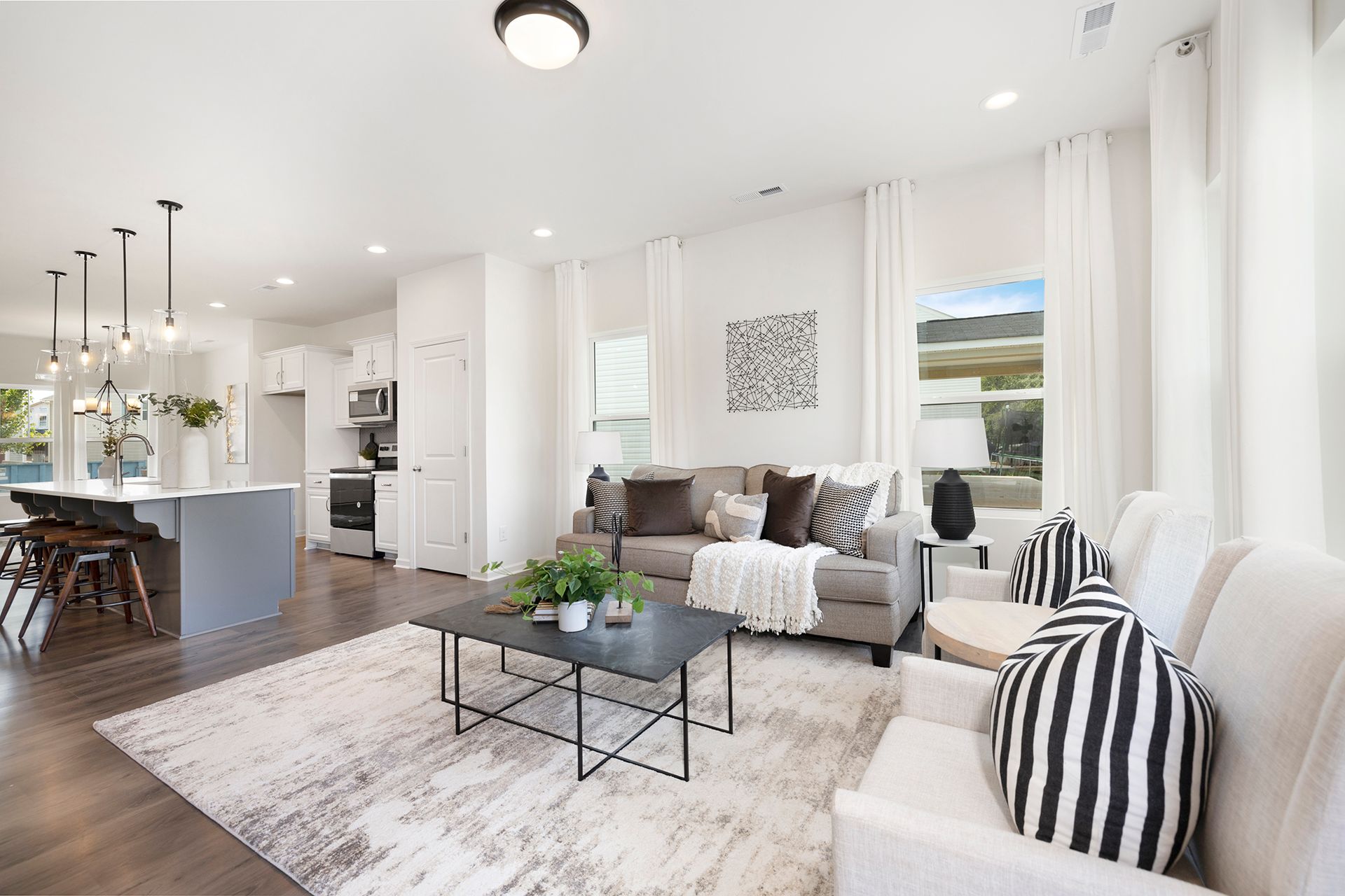 A living room with a couch , chair , coffee table and rug.