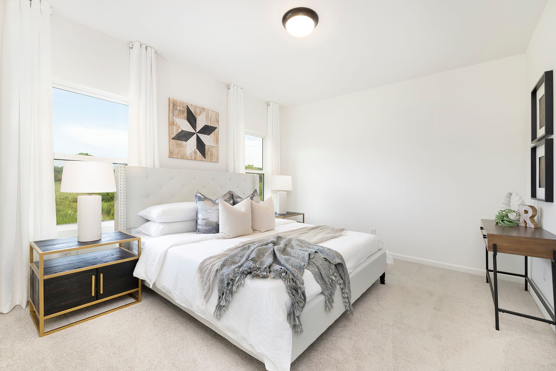 A bedroom with a bed , nightstand , lamps and a window.