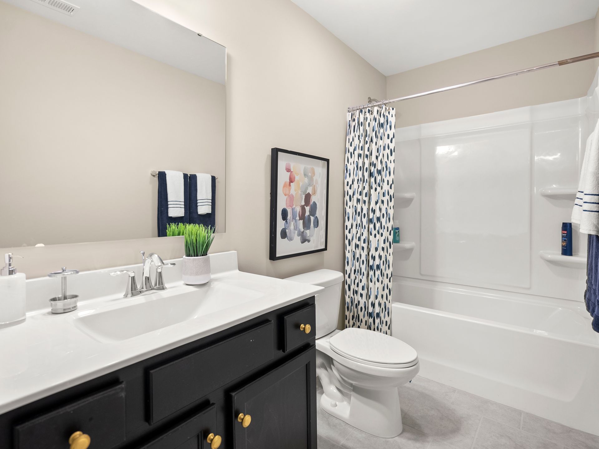 A bathroom with a sink , toilet , bathtub and mirror.