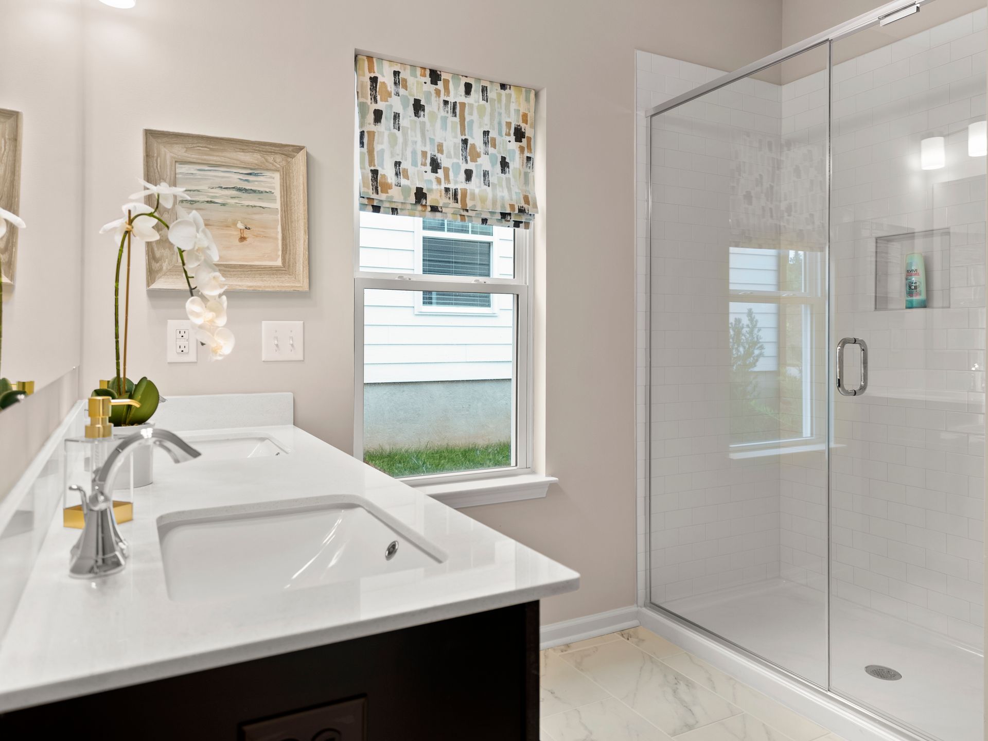 A bathroom with a sink and a walk in shower.