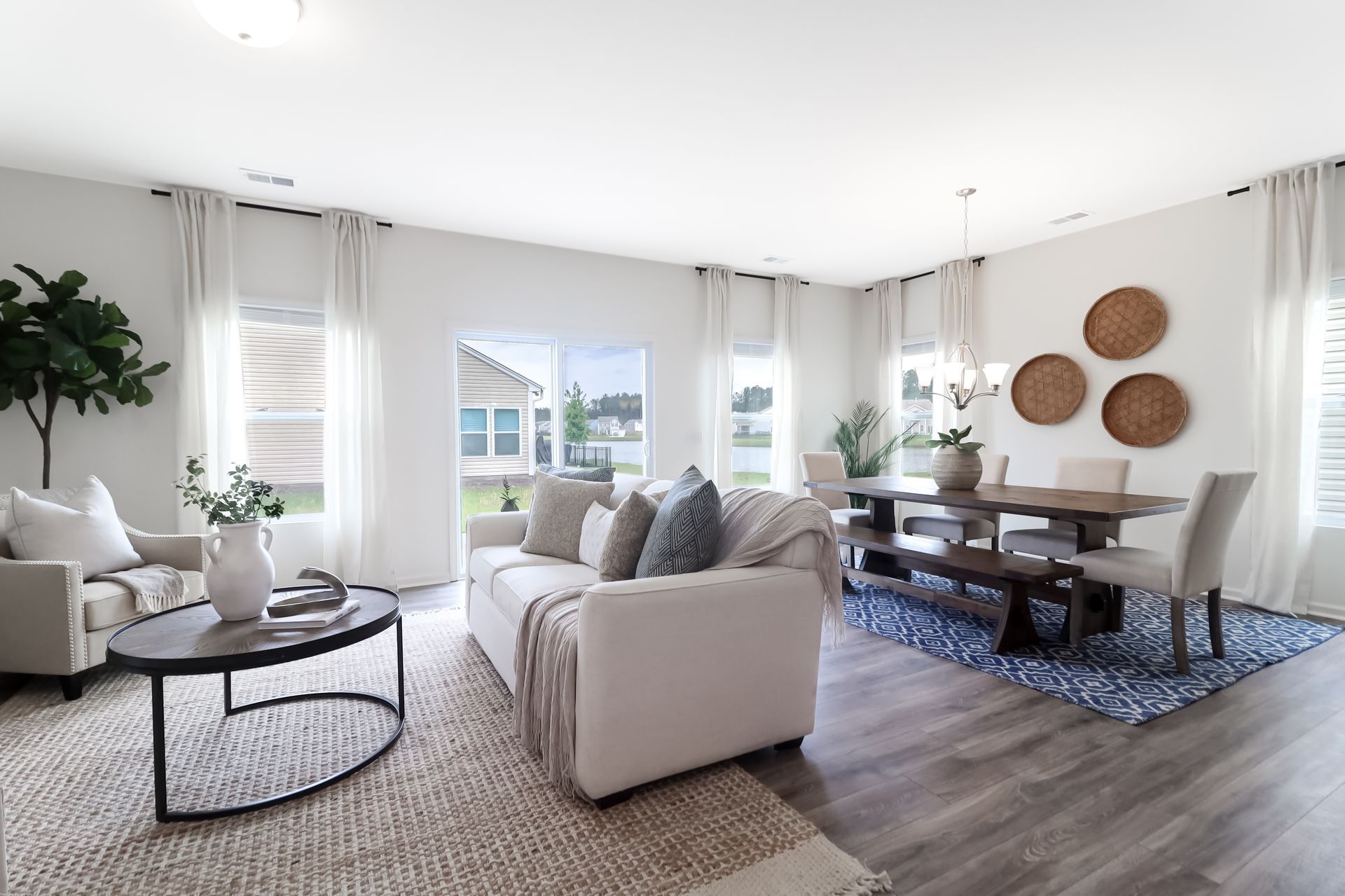 A living room with a couch , table , chairs and a rug.