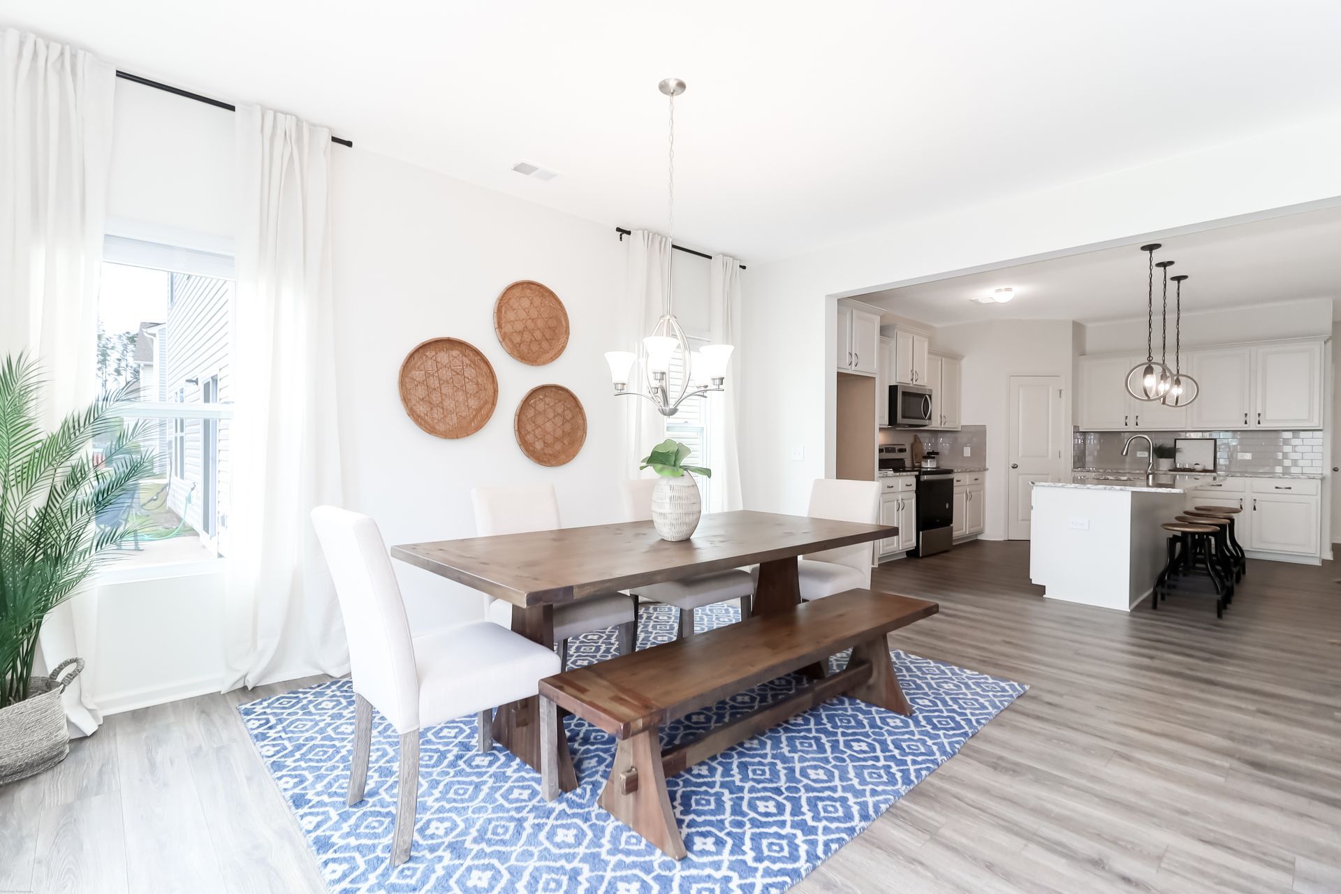 A dining room with a table and chairs and a bench.
