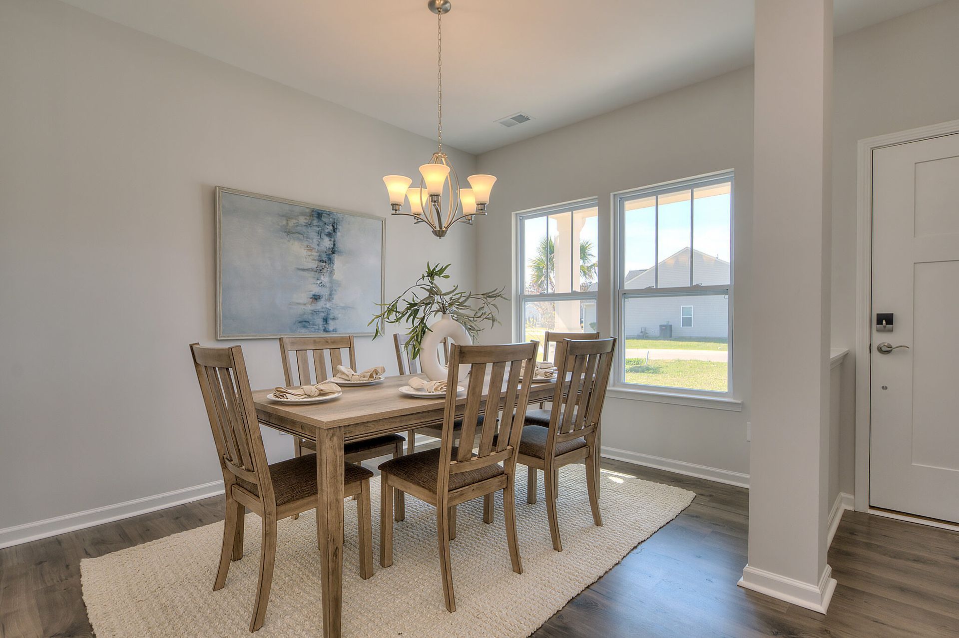 A dining room with a table and chairs and a chandelier.