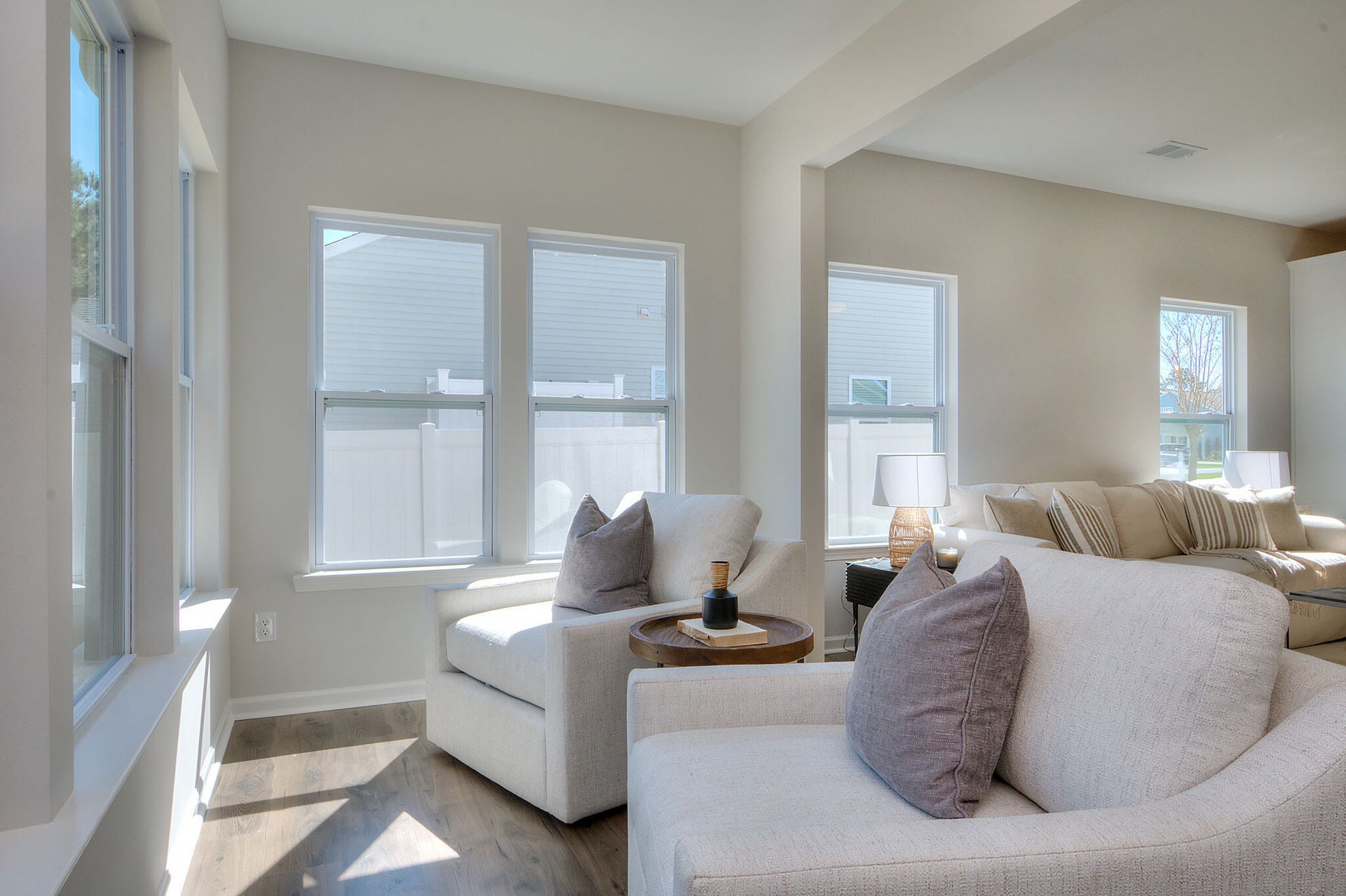 A living room with a couch , chair , table and windows