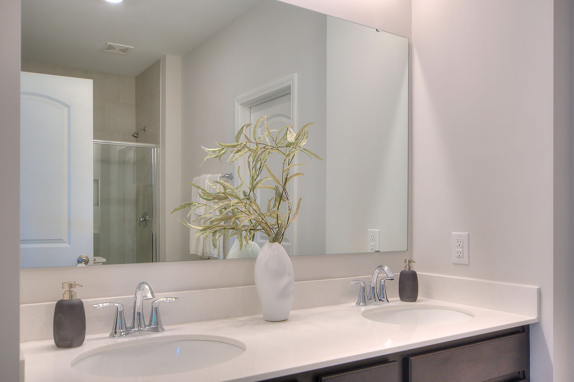 A bathroom with two sinks and a large mirror.