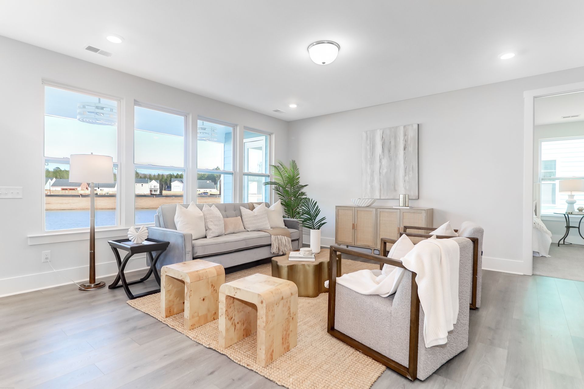 A living room with a couch , chairs , tables and a rug.