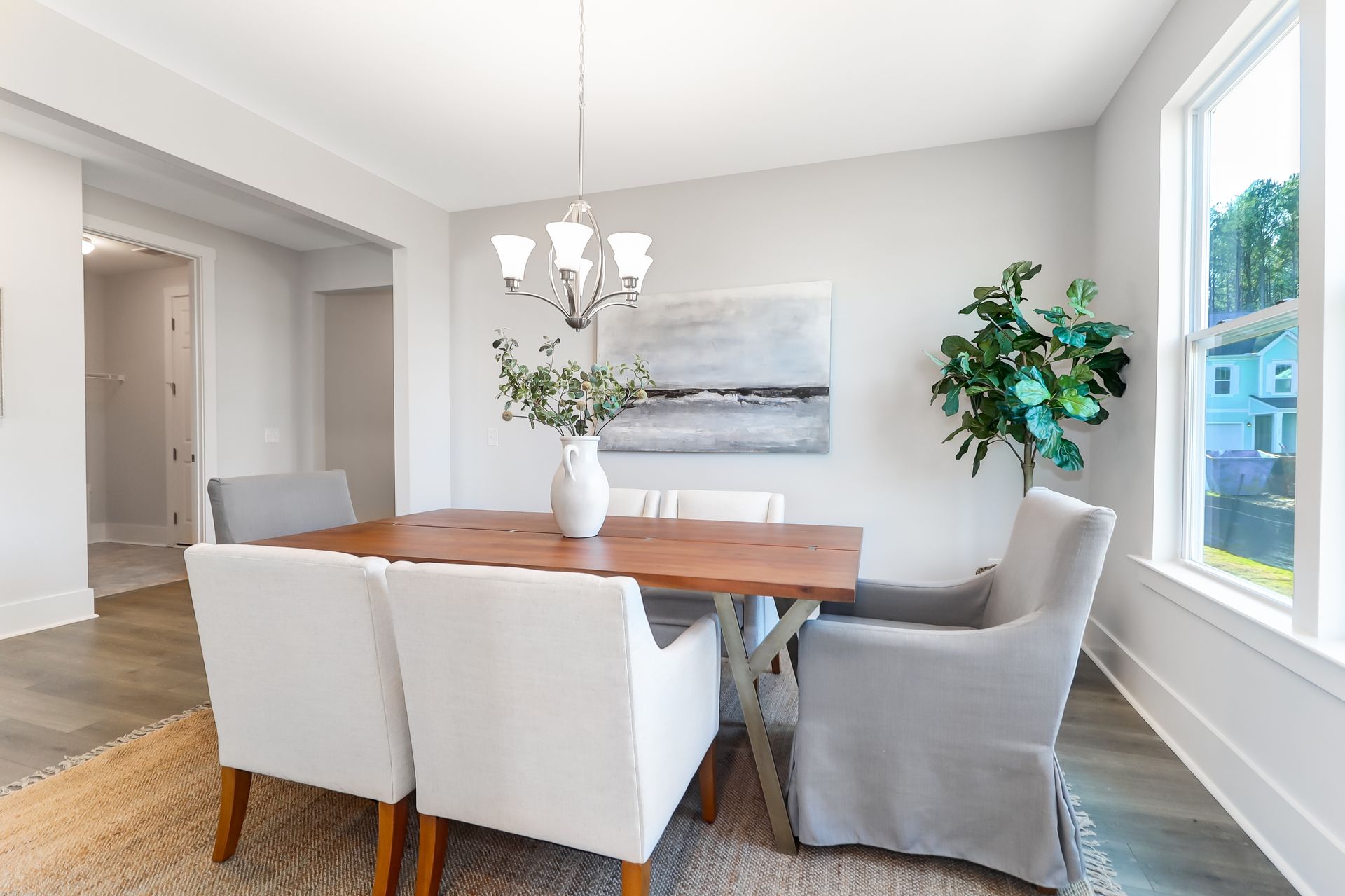 A dining room with a table and chairs and a chandelier.