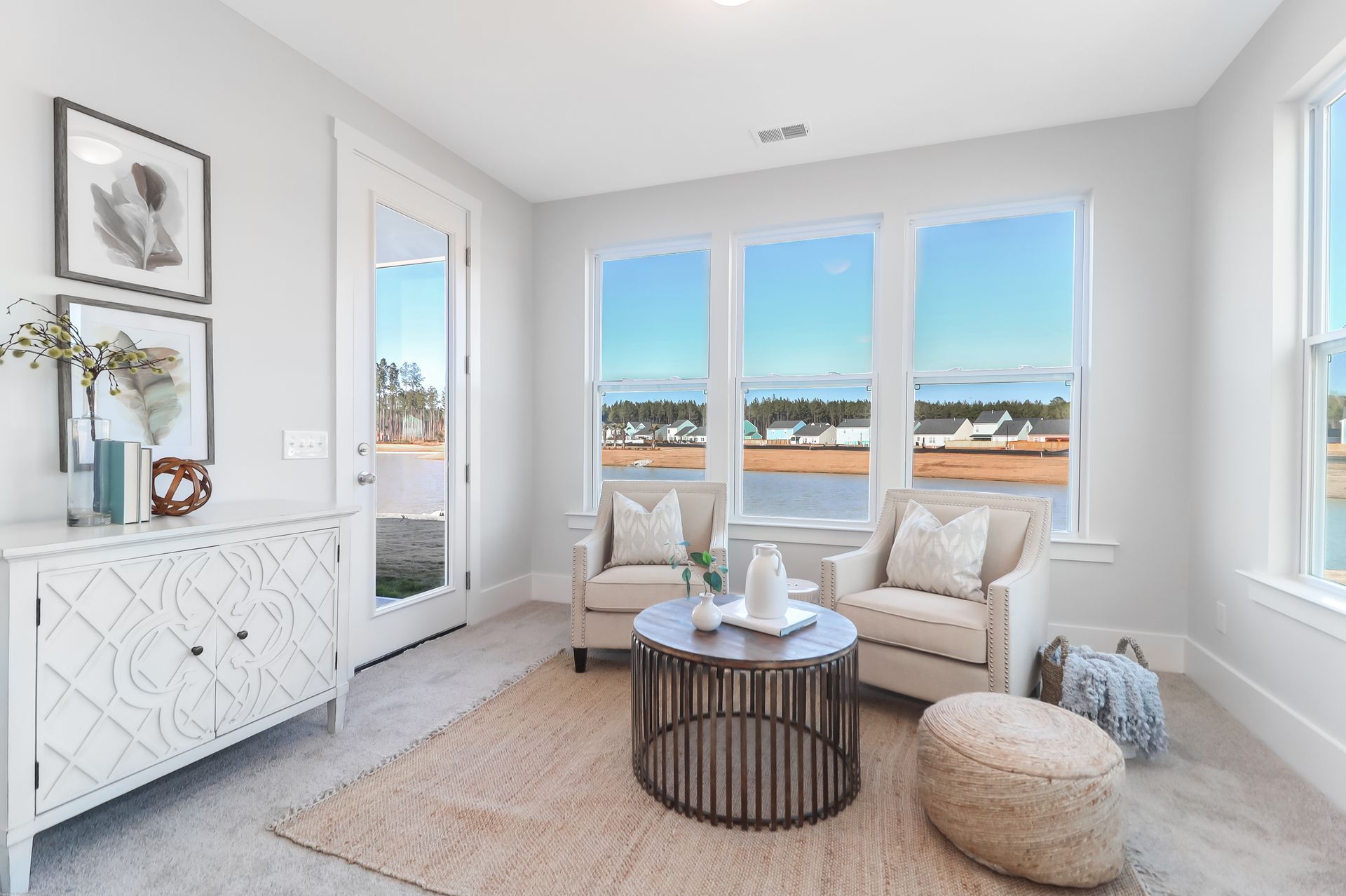 A living room with two chairs , a coffee table , and a dresser.