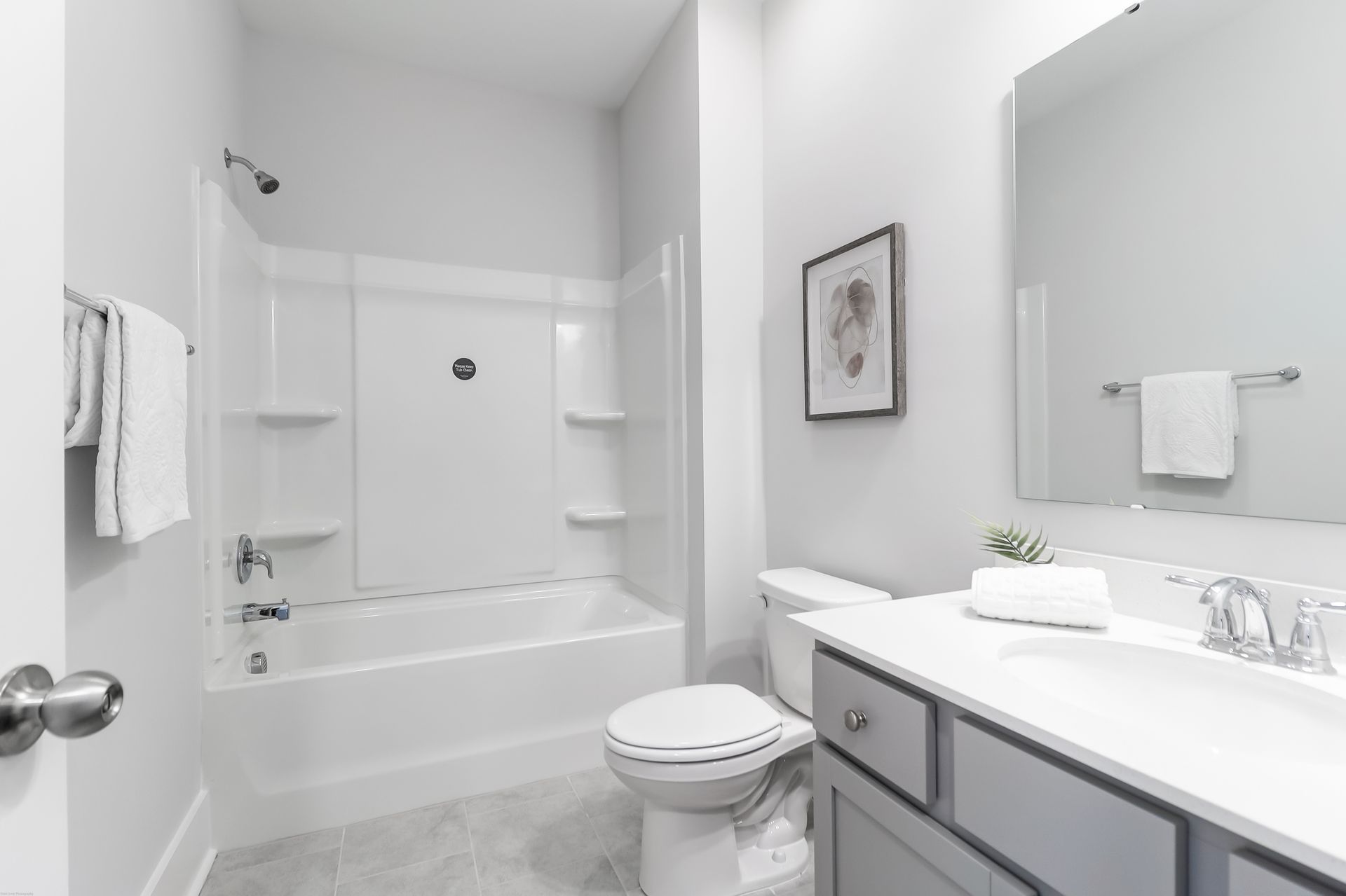 A bathroom with a toilet , sink , bathtub and mirror.