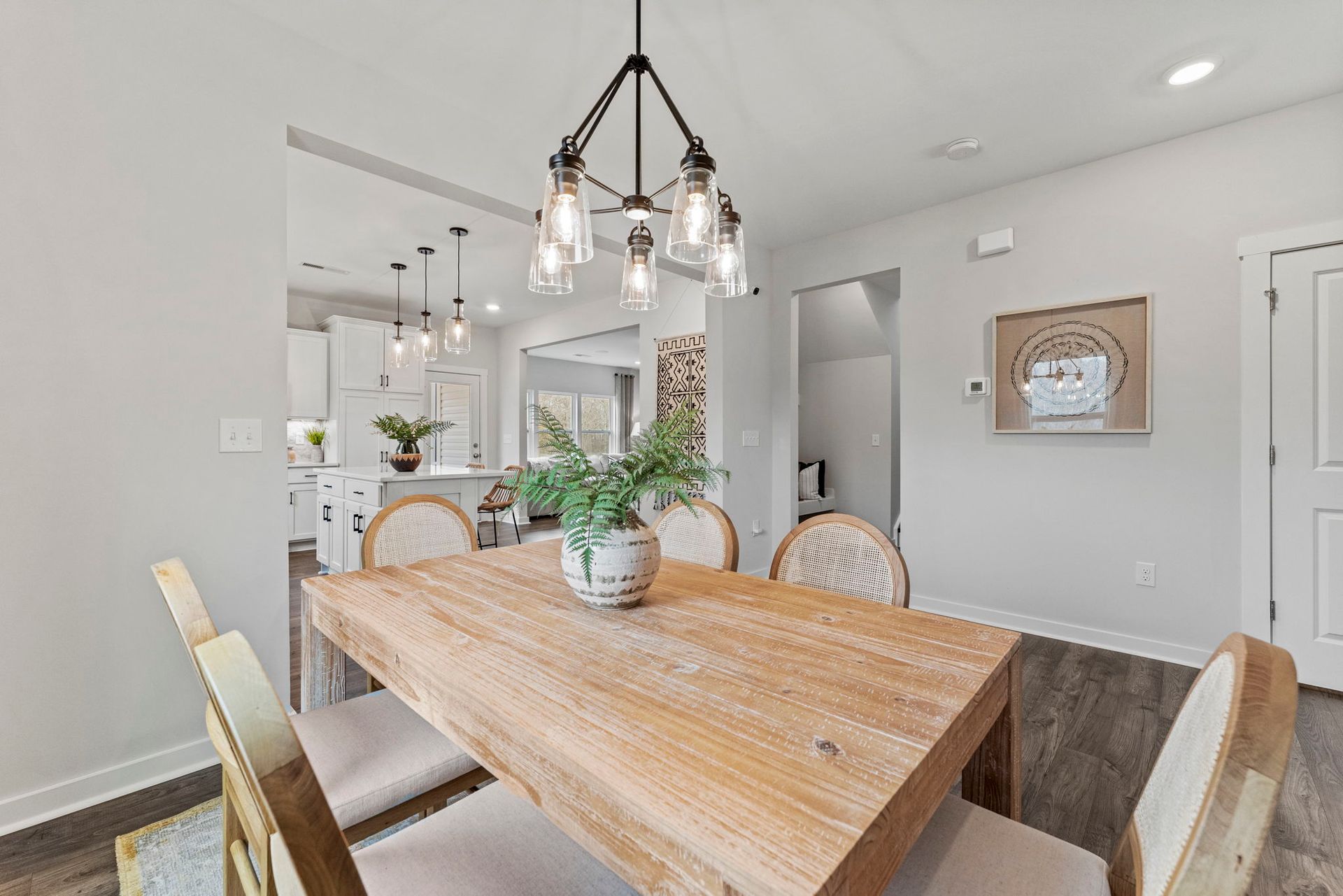 a dining room with a wooden table and chairs and a chandelier hanging from the ceiling .