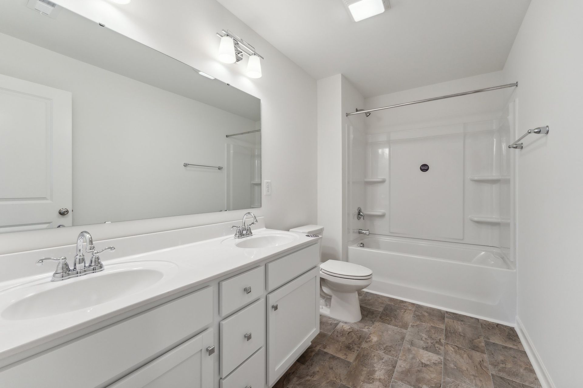 A bathroom with two sinks , a toilet , and a bathtub.