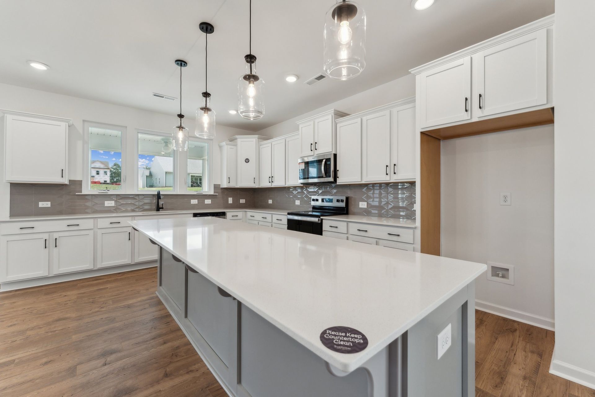 A kitchen with white cabinets and a large island in the middle.