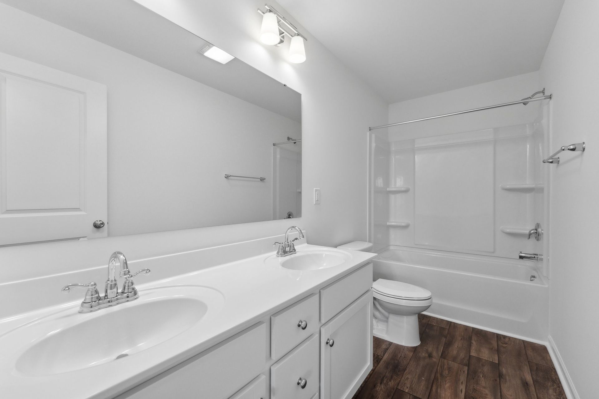 A bathroom with a sink , toilet , tub and mirror.