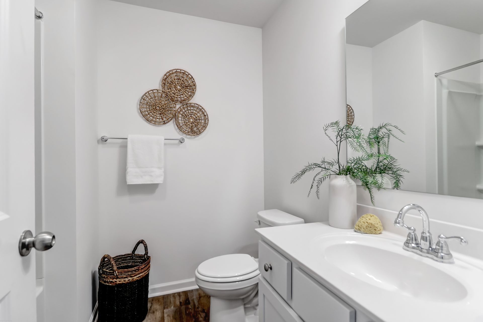 A bathroom with a toilet , sink and mirror.