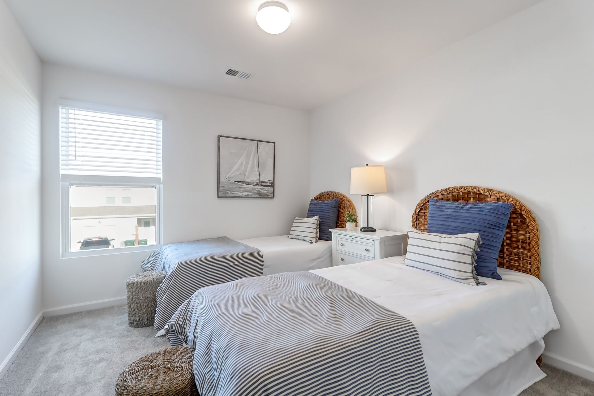 A bedroom with two twin beds and a window.