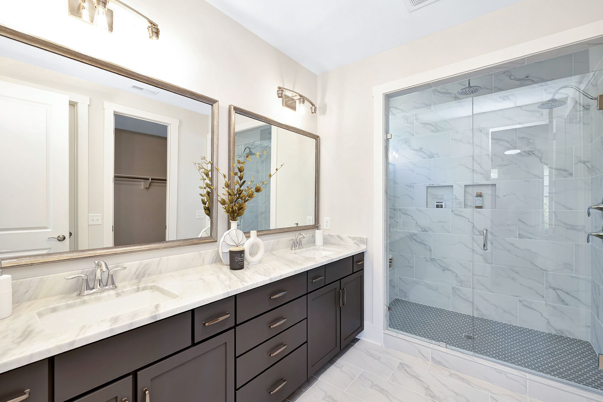 A bathroom with two sinks and a walk in shower.