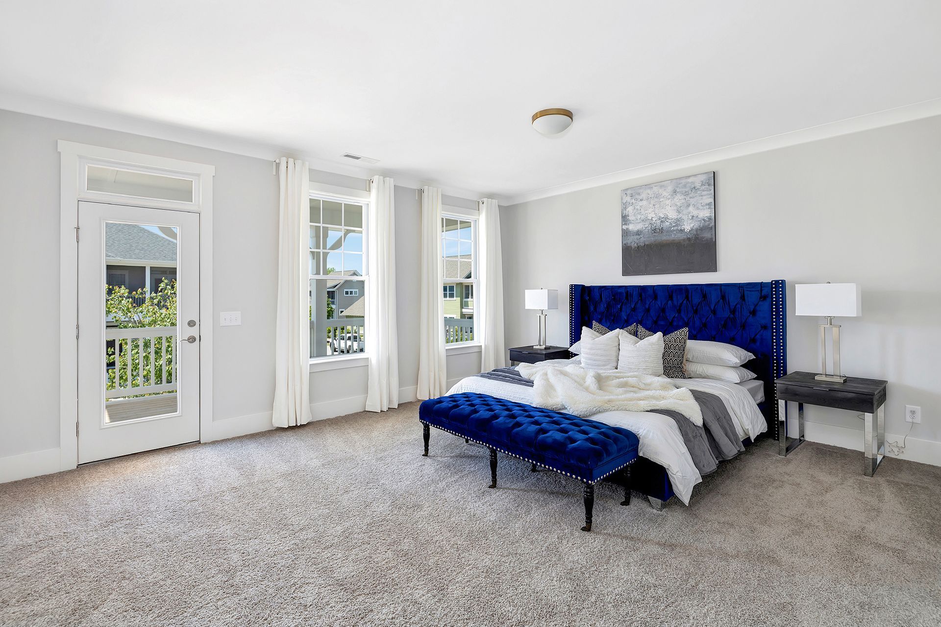A bedroom with a blue bed and a blue bench.