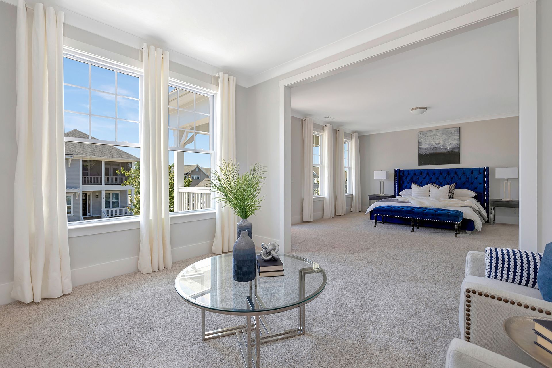 A bedroom with a large bed and a glass coffee table.
