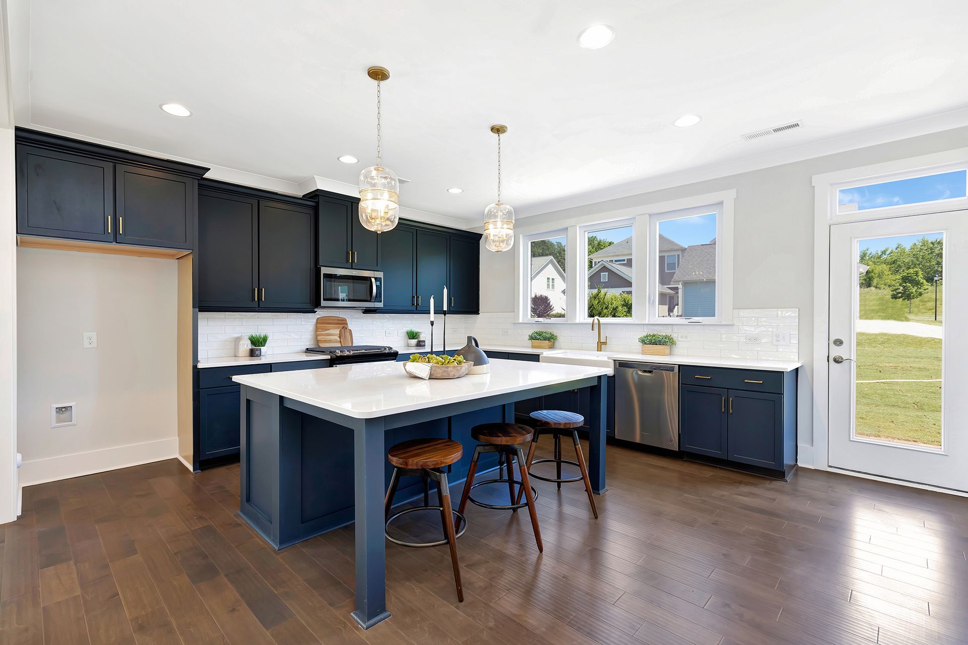 A kitchen with blue cabinets and a large island in the middle.