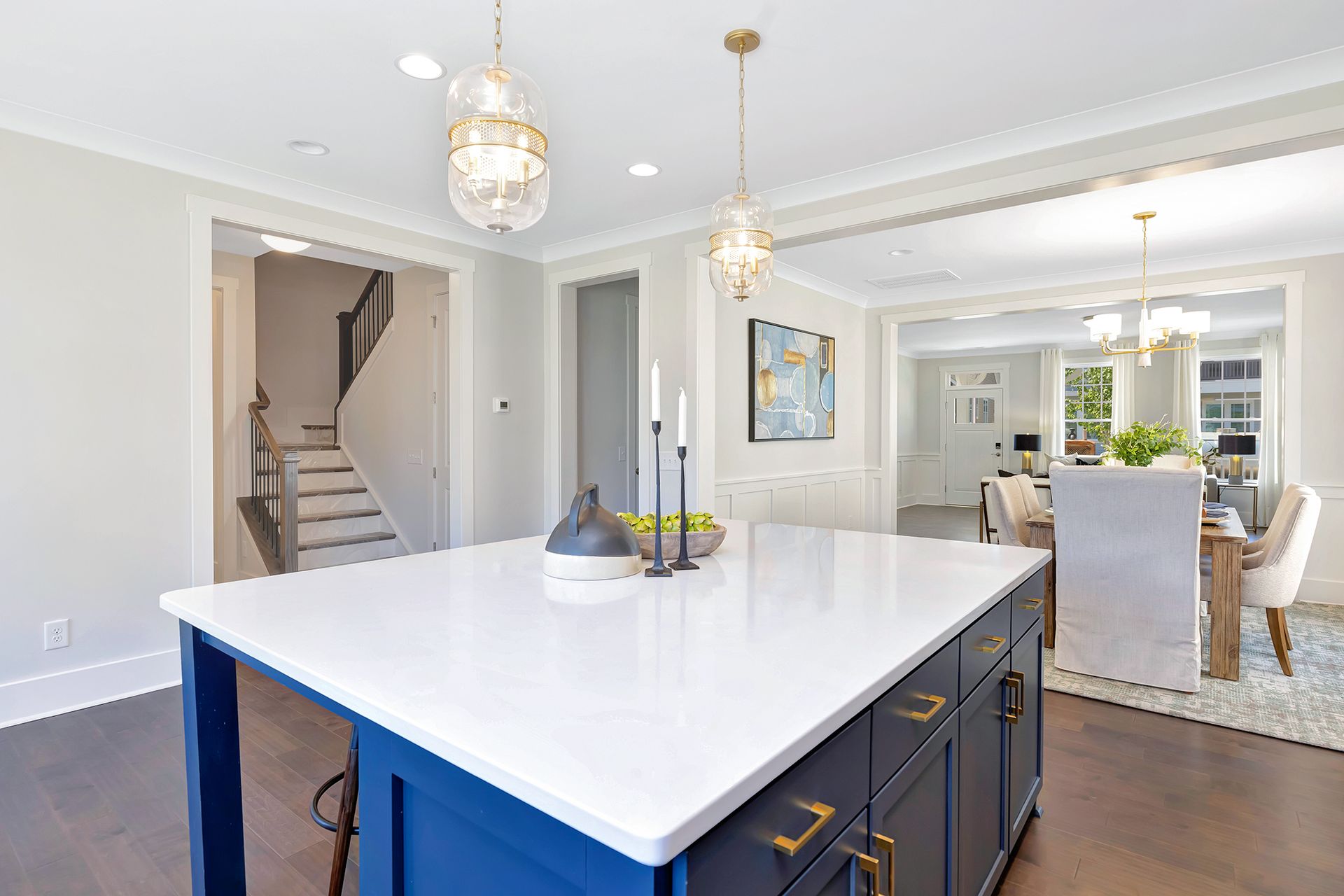 A kitchen with a blue island and white counter tops.