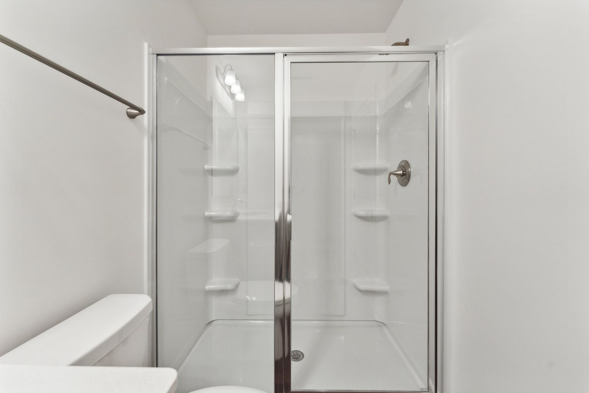 A bathroom with a toilet and a shower with a glass door.