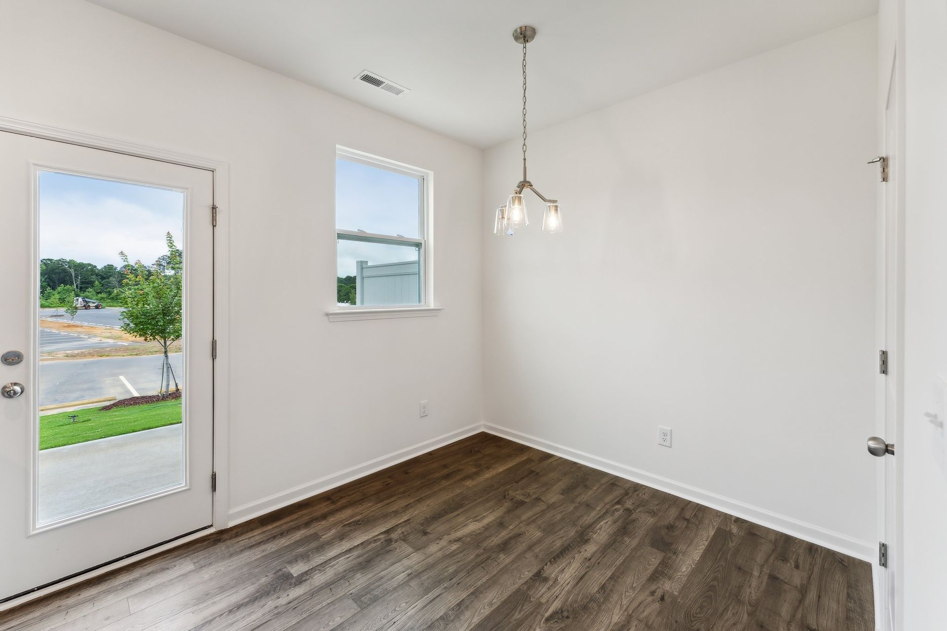 An empty room with hardwood floors and a window.