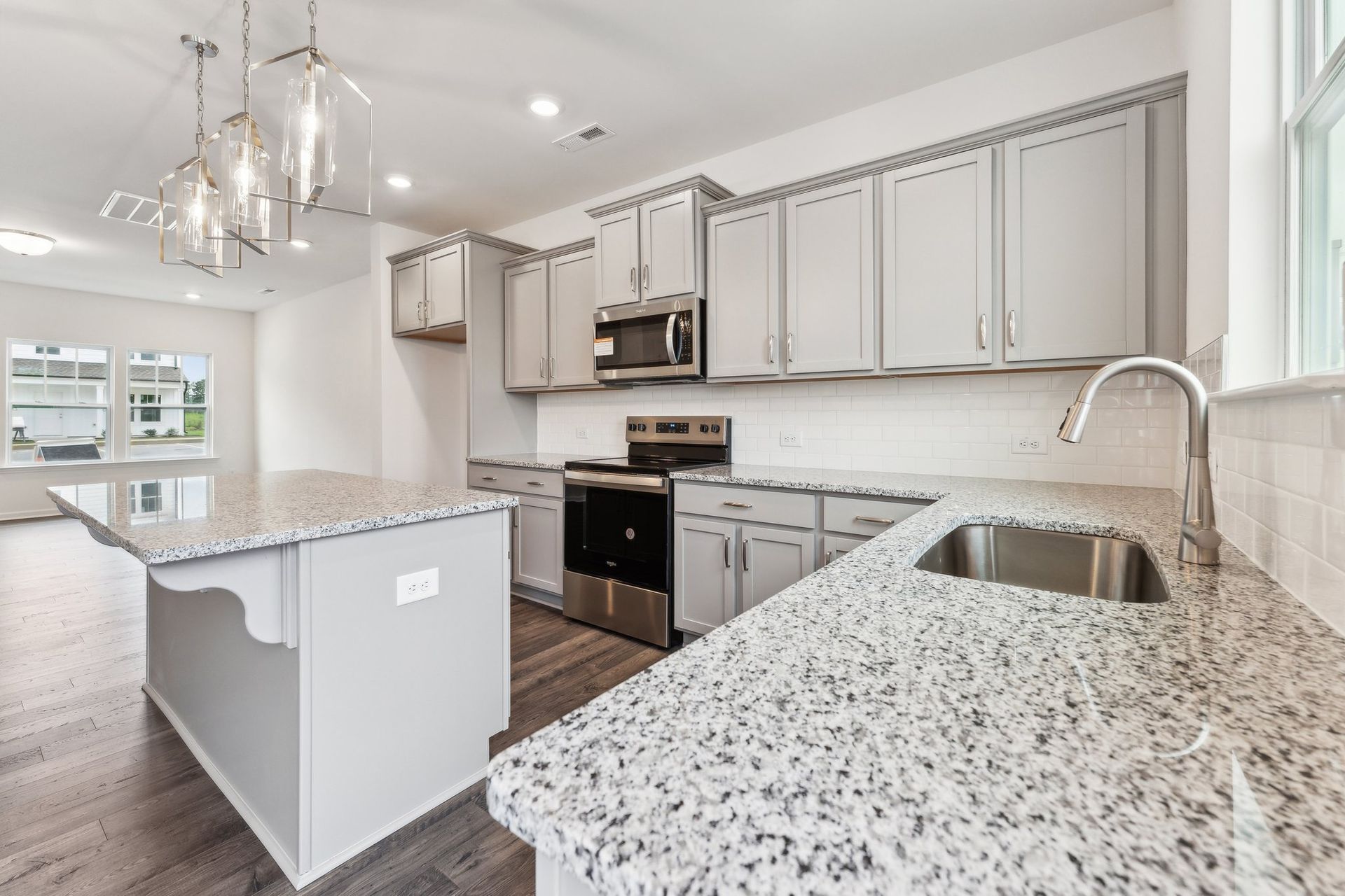 A kitchen with granite counter tops and stainless steel appliances.