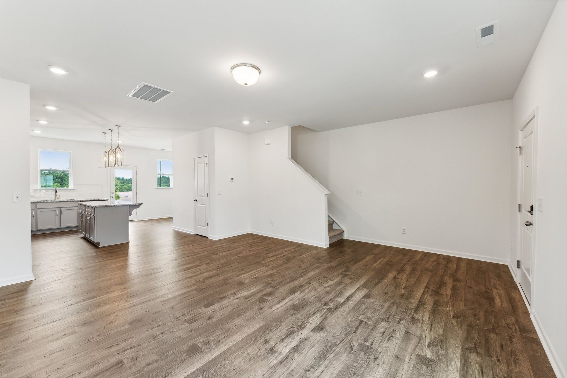 An empty living room with hardwood floors in a new home.