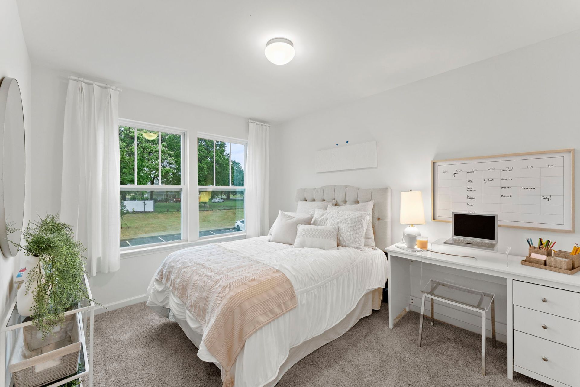 A bedroom with a bed , desk , and window.