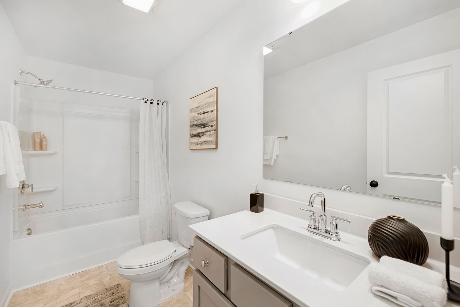 A bathroom with a sink , toilet , bathtub and mirror.