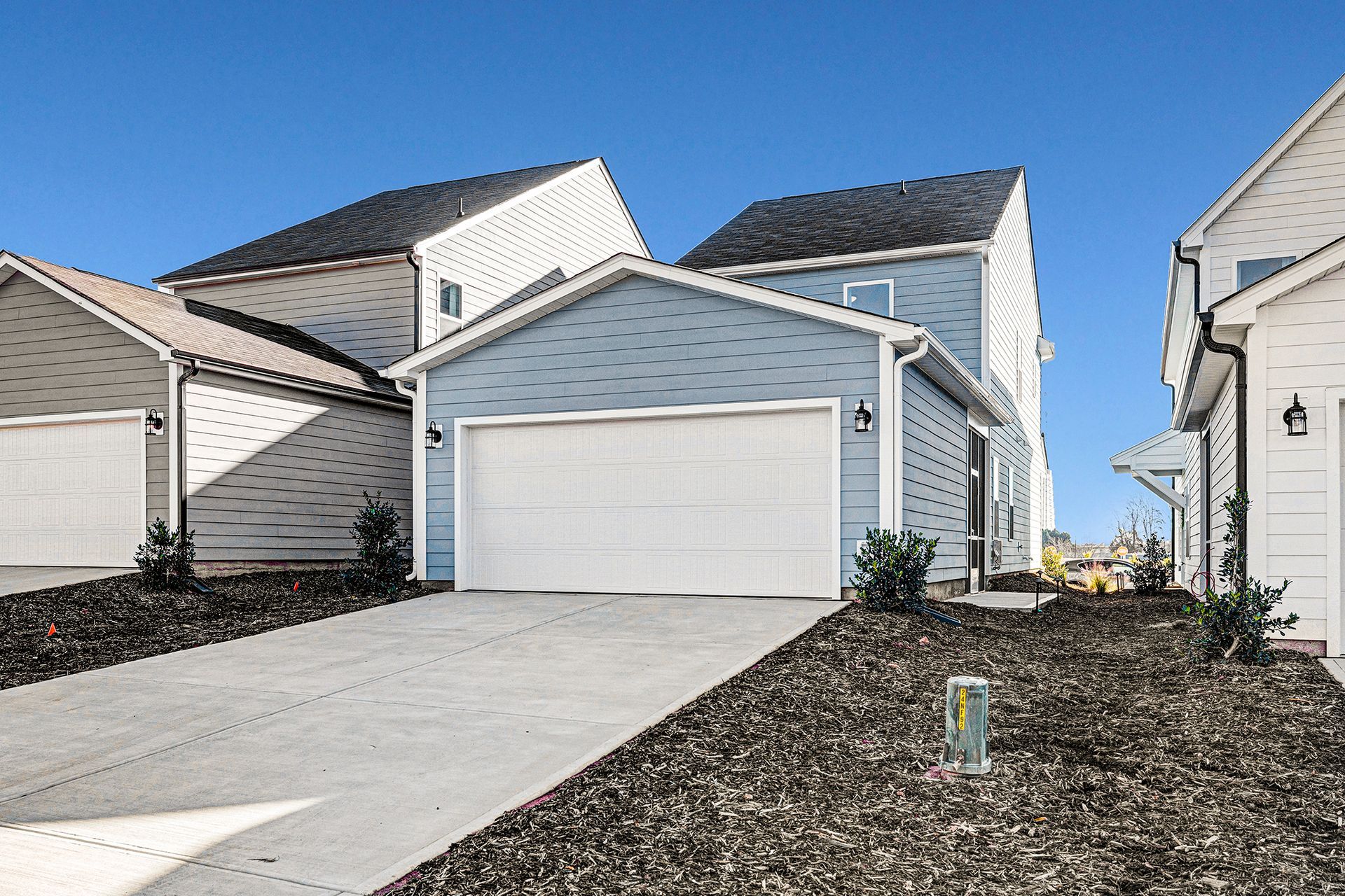 A blue and white house with a white garage door