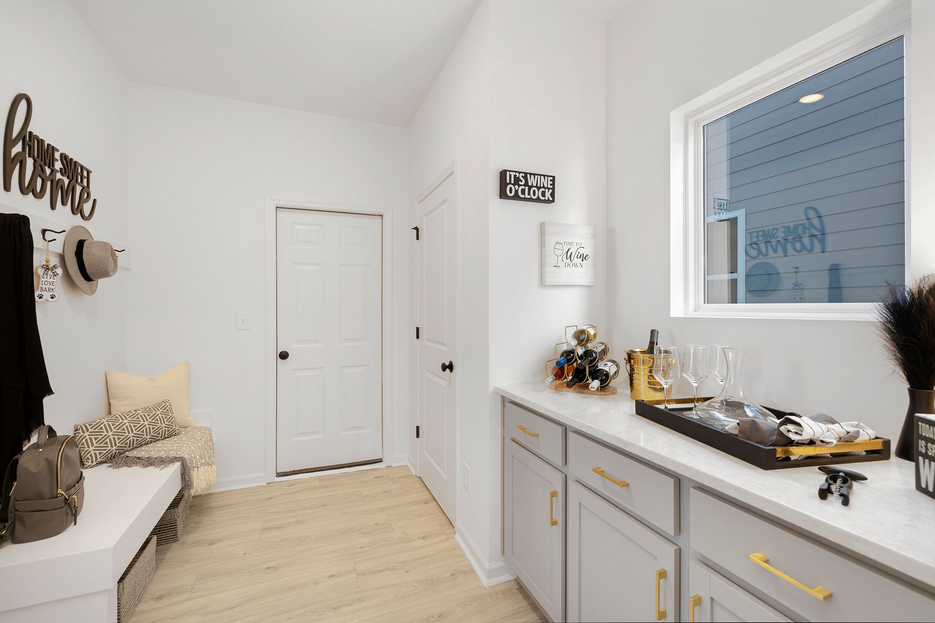 A kitchen with a window , cabinets , and a bench.