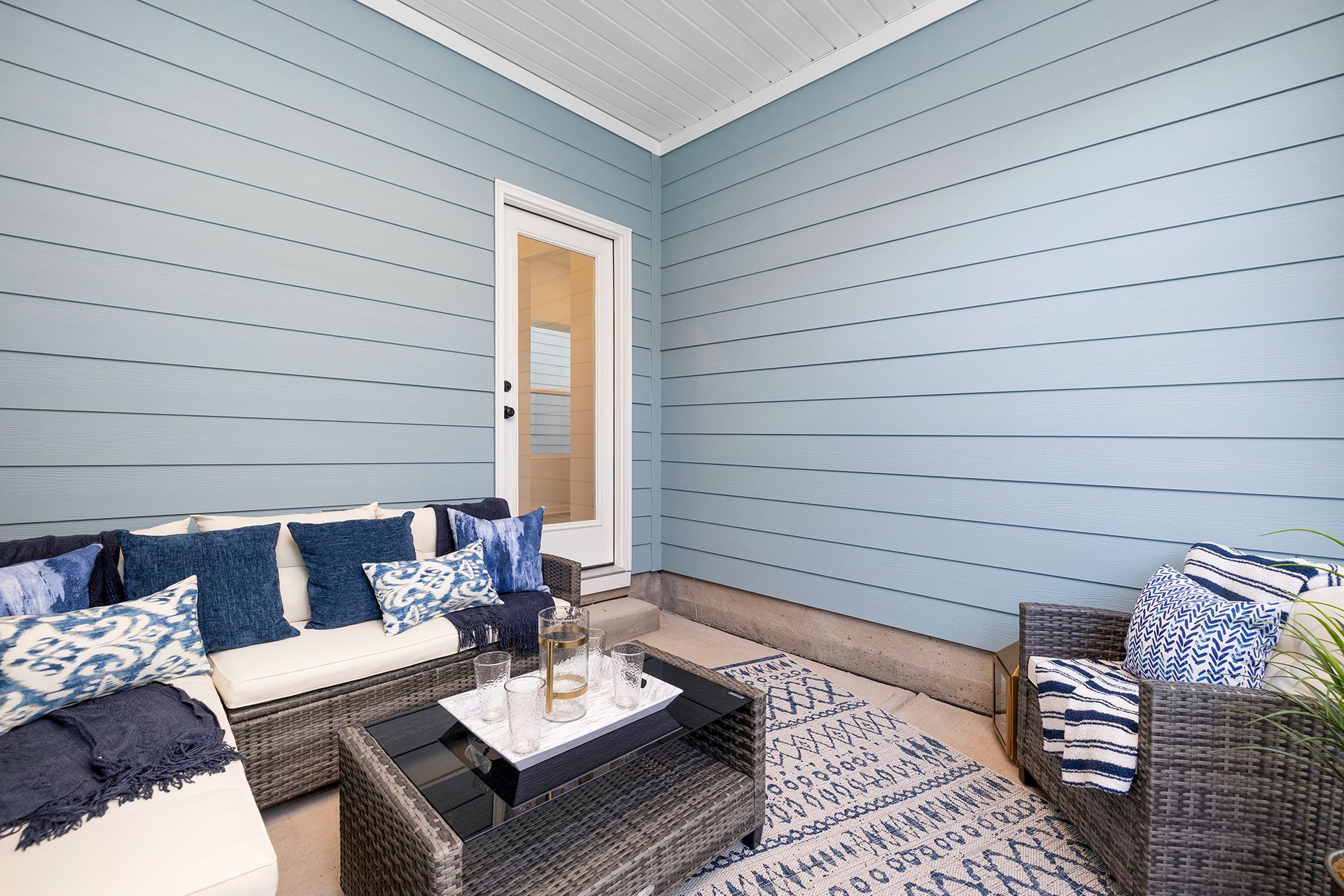 A living room with a couch , chair , coffee table and rug.