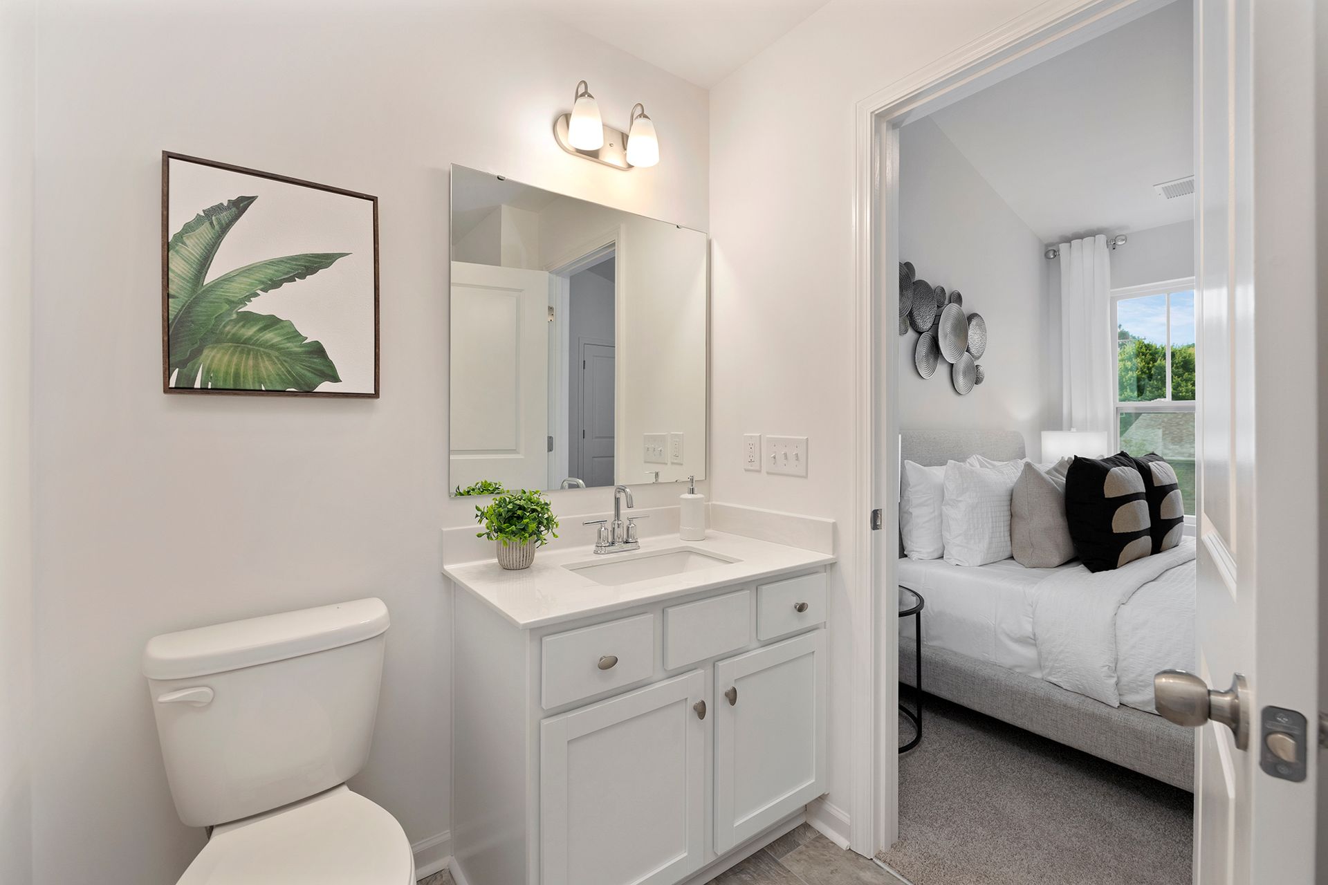 A bathroom with a toilet , sink and mirror.