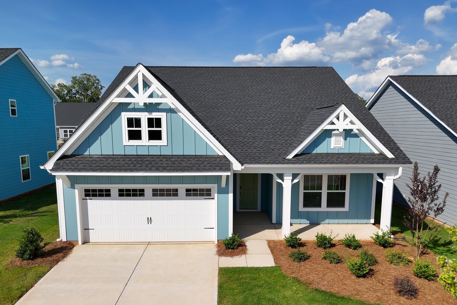 A blue and white house with a garage and a porch.