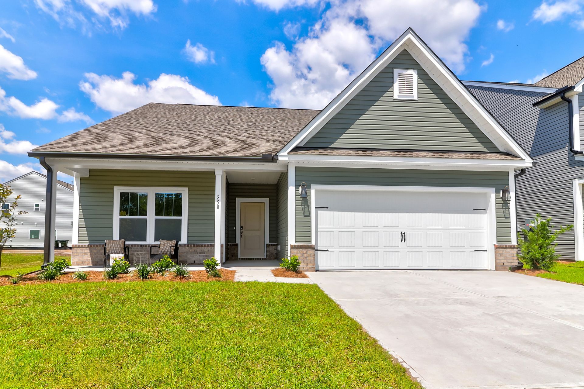 The front of a house with a white garage door and a porch.