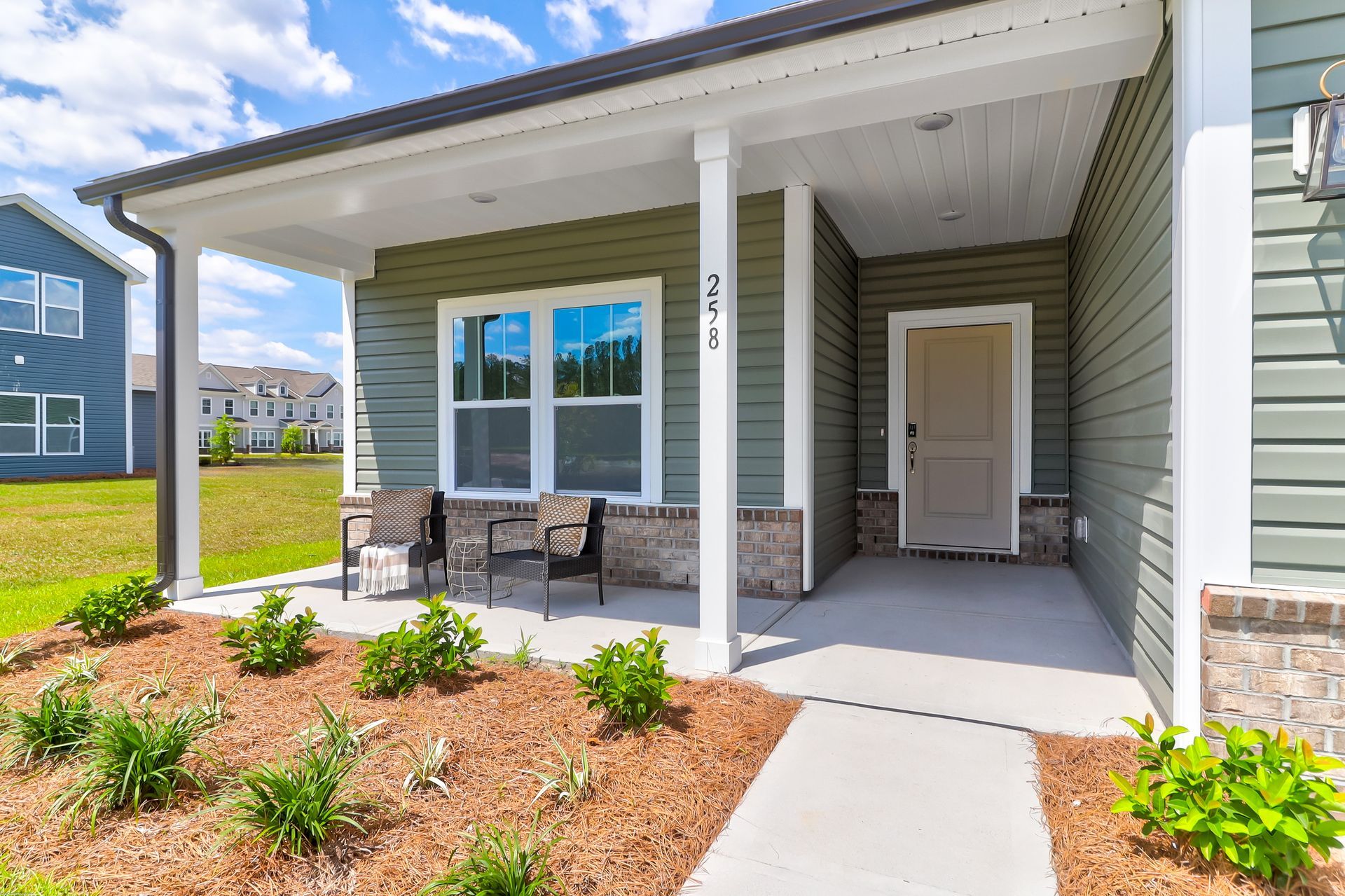 A small house with a porch and a walkway leading to it.