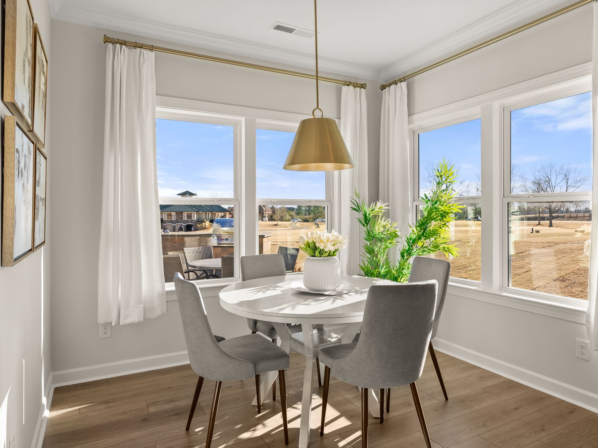 A dining room with a table and chairs and a lot of windows.